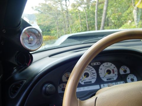 1995 Ford Mustang - The interior of a 1995 Ford Mustang is visible, a turbo gauge and the dashboard instruments.