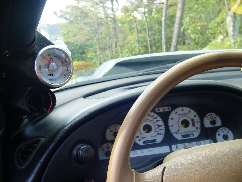 Interior of a 1995 Ford Mustang with a turbo gauge and dashboard