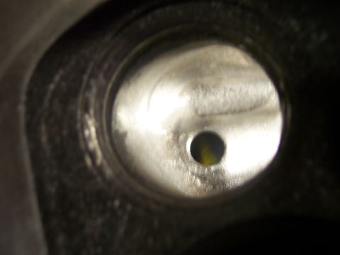 1967 Ford Mustang - Interior view of an engine cylinder head port with a small central hole visible.