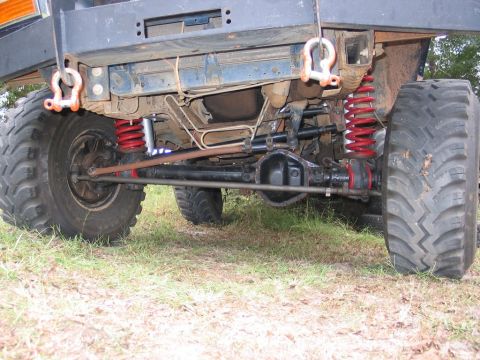 1995 Ford Bronco - Close-up view of the rear axle, suspension components, and large tires of a modified off-road vehicle.
