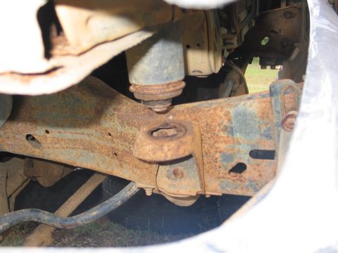 1989 Ford F-150 - The underside of a truck shows significant rust on the frame and suspension components.
