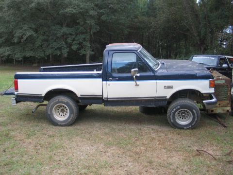 1989 Ford F-150 - Side view of a two-tone blue and white Ford F-150 pickup truck parked outdoors.