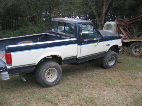 1989 Ford F-150 - This 1989 Ford F-150 pickup truck is seen in a yard with another vehicle in the background.