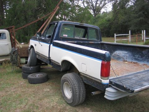 1989 Ford F-150 - This pickup truck appears to be from the late 1980s, possibly a 1987-1991 Ford F-Series, and is propped up on tires.