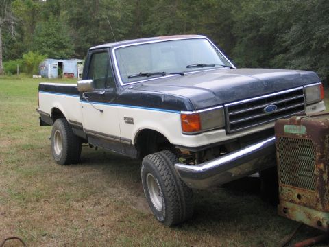 1989 Ford F-150 - This two-tone Ford F-150 pickup truck is shown from a three-quarter front angle, parked outdoors.
