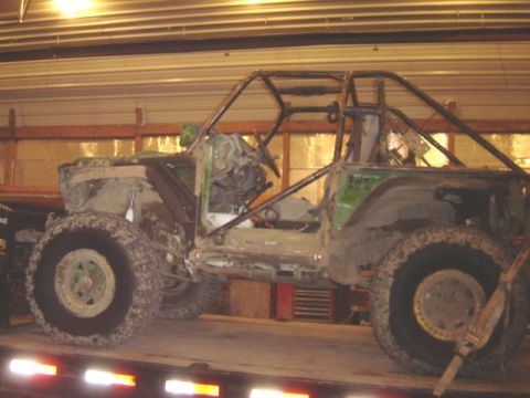 1992 Ford Bronco - Custom off-road buggy with roll cage and large tires is loaded onto a trailer.