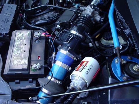 2000 Ford Taurus - Close-up view of a vehicle's engine bay, highlighting the oil filter and air intake system.