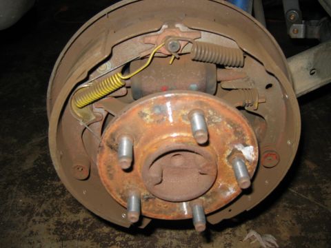 1985 Ford LTD Crown Victoria - Close-up of a rear drum brake assembly, showing the internal components and rusty wheel hub.