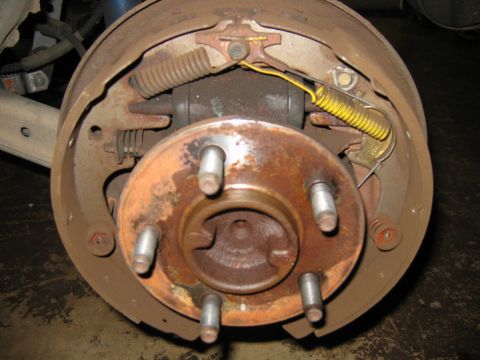 1985 Ford LTD Crown Victoria - Drum brake assembly showing wear and tear, including rust on the rotor and brake components.