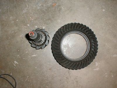 1985 Ford LTD Crown Victoria - A set of differential gears, including a pinion gear and a ring gear, are shown on a concrete surface.