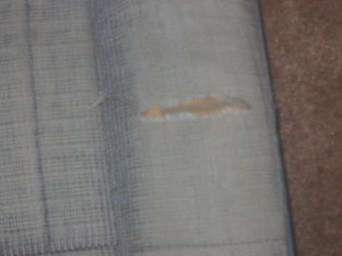 1991 Ford Bronco - A close-up view of damaged fabric, showing a tear with exposed material.