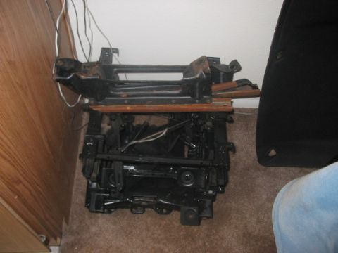 1991 Ford Bronco - A disassembled seat frame is shown, possibly for a Ford Bronco, with visible wooden supports and wiring.