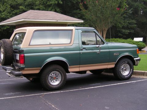 1989 Ford Bronco - This 1989 Ford Bronco features a two-tone green and tan paint scheme with a spare tire mounted on the rear.