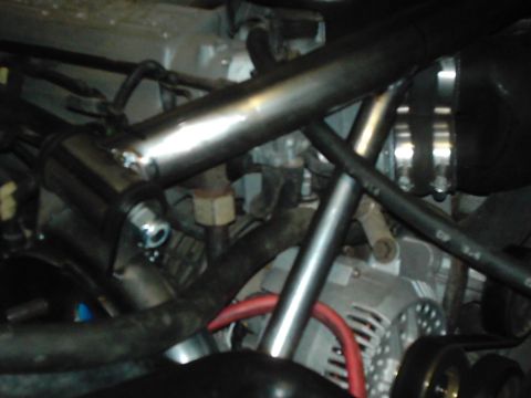 1978 Ford Bronco - A detailed view of various engine components, including hoses and the alternator, within the engine bay.