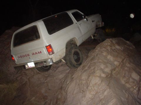 1981 Ford F-150 - A white Dodge Ram SUV navigates rocky terrain at night, displaying its rear badging.