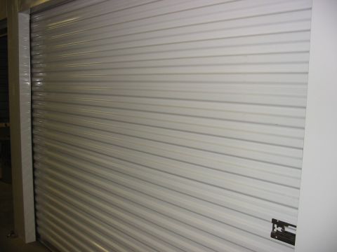 1991 Ford Bronco - Corrugated metal garage door with a Supermotors.net logo visible.