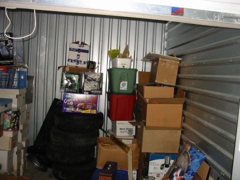 1991 Ford Bronco - A cluttered storage unit filled with boxes, tires, and other miscellaneous items.