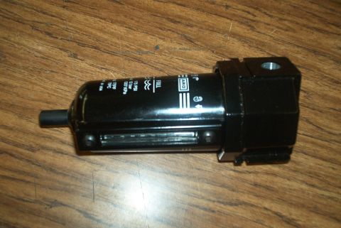 1983 Ford Bronco - This black air filter regulator features pressure markings and the ARO logo, indicating its function in air system regulation.