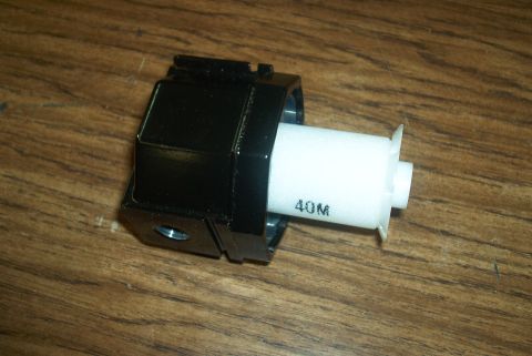 1983 Ford Bronco - Close-up of an automotive part with '40M' visible on a white cylinder.