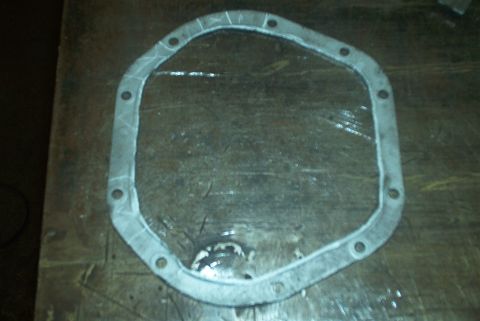 1983 Ford Bronco - Differential cover gasket on a workbench.