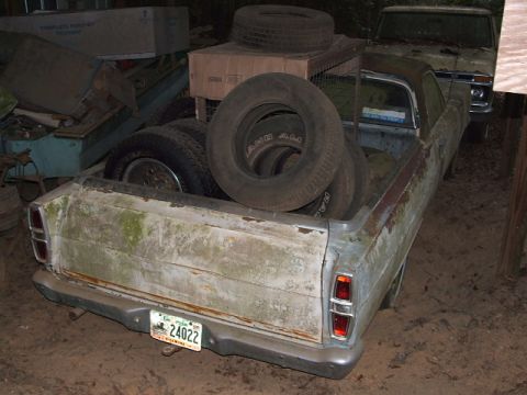 1966 Ford Ranchero - This 1966 Ford Ranchero is seen from the rear, covered in moss and carrying several tires in its bed.