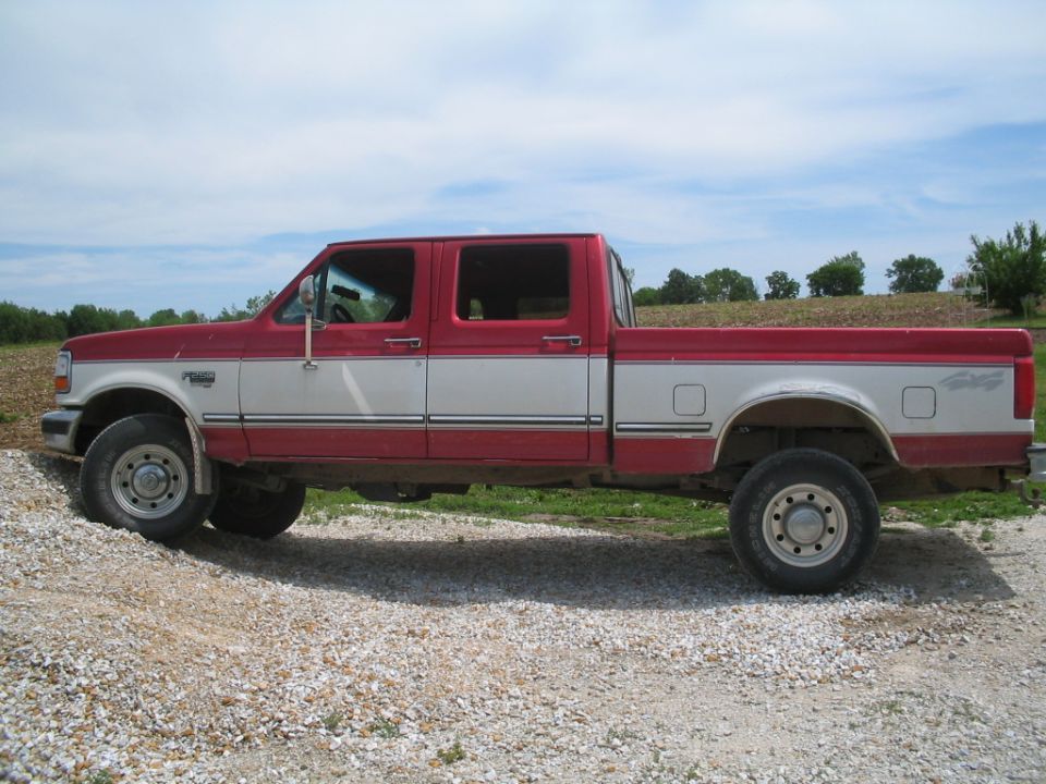 Red and white crew cab pickup truck, side view