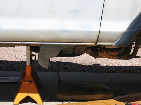 1978 Ford Bronco - Undercarriage view of a vehicle supported by jack stands, with visible exhaust components.