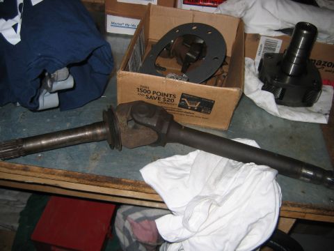 1992 Ford Bronco - Driveshaft and differential components are laid out on a workbench, with a cardboard box in the background.