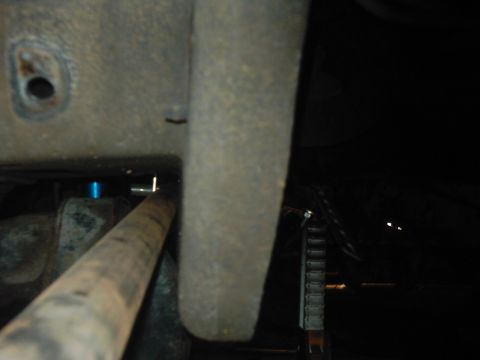 1978 Ford Bronco - Underside view of a vehicle, showing mechanical components and a rusty pipe.