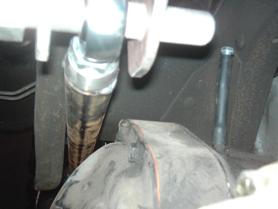 Close-up of a rusty exhaust pipe and suspension parts under a vehicle