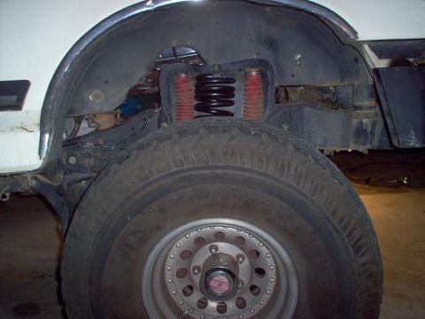 1988 Ford Bronco - Close-up view of the front wheel well of a 1988 Ford Bronco, highlighting the coil spring and suspension system.
