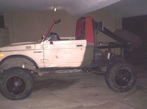 1987 Suzuki Samurai - Suzuki Samurai modified with a rear rack and spare tire carrier.