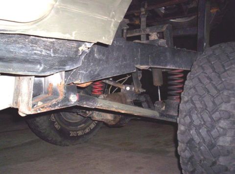 1987 Suzuki Samurai - This photo shows the undercarriage of a vehicle, focusing on the suspension and a large tire.