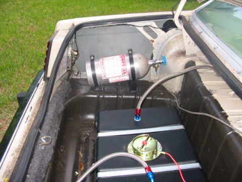 1985 Ford LTD Crown Victoria - The trunk of a car shows a nitrous oxide tank and a fuel cell, indicating performance modifications.