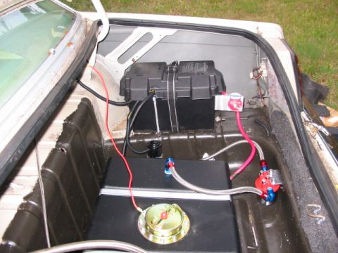 1985 Ford LTD Crown Victoria - The trunk of a car shows a custom fuel system and battery installation.