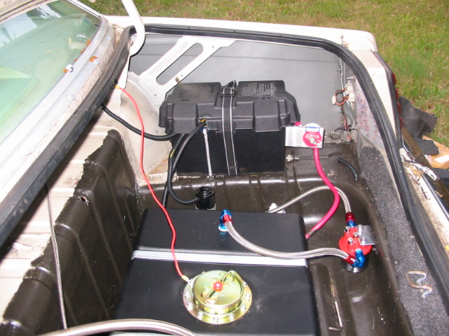 Car trunk interior with a black fuel cell, battery, and red fuel lines