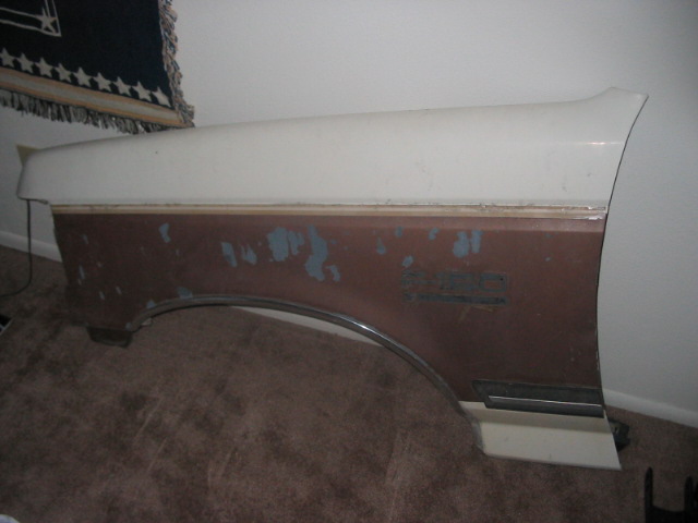 vehicle fender with peeling paint and a chrome trim piece