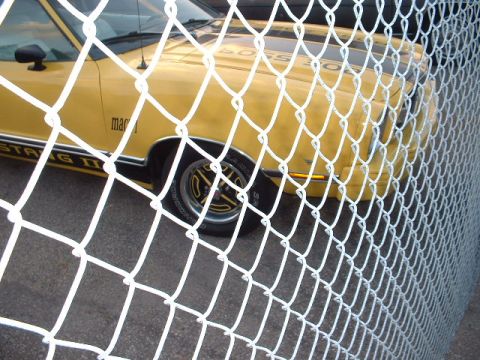 1978 Ford Mustang II - 1978 Ford Mustang II, visible through a chain-link fence.