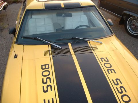 1978 Ford Mustang II - The hood of a yellow car features black racing stripes and 'BOSS 302' lettering.