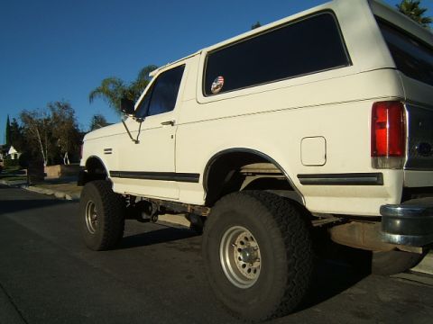 1988 Ford Bronco - Side view of a lifted 1988 Ford Bronco with large tires.