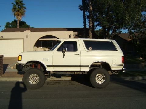 1988 Ford Bronco - This lifted 1988 Ford Bronco has a custom suspension setup and is parked on a residential street.
