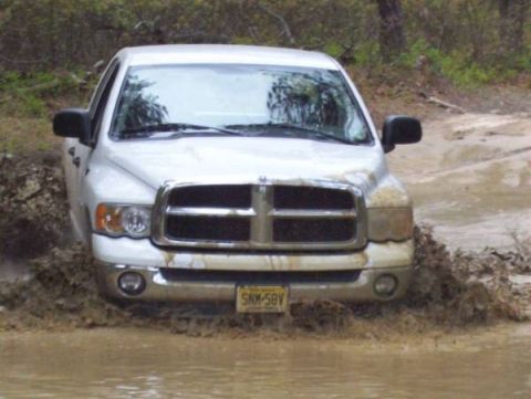 2005 Dodge 1500 - This Dodge Ram is navigating through a muddy off-road trail, kicking up a lot of water.