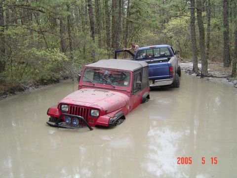 2005 Dodge 1500 - Two off-road vehicles are stuck in deep mud on a wooded trail, with a date stamp indicating May 15, 2005.
