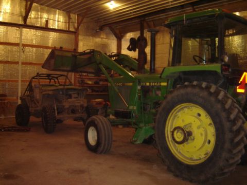 1992 Ford Bronco - Tractor and buggy parked inside a garage.
