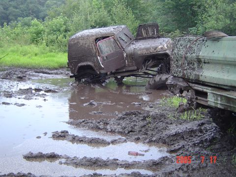 2005 Dodge 1500 - Off-road vehicles are stuck in a muddy bog after attempting to traverse the difficult terrain.