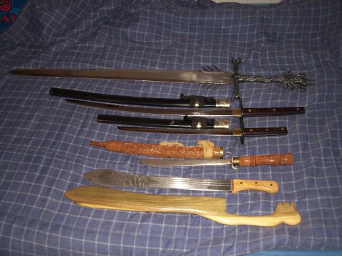 1995 Ford Bronco - A variety of bladed weapons, including swords and knives, are displayed on a patterned cloth.