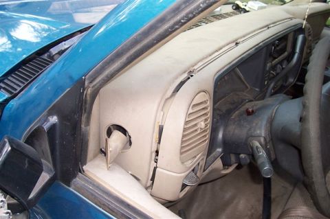 1987 Ford Bronco - Close-up of a vehicle's interior dashboard and steering column, showing vents and dislodged trim pieces.