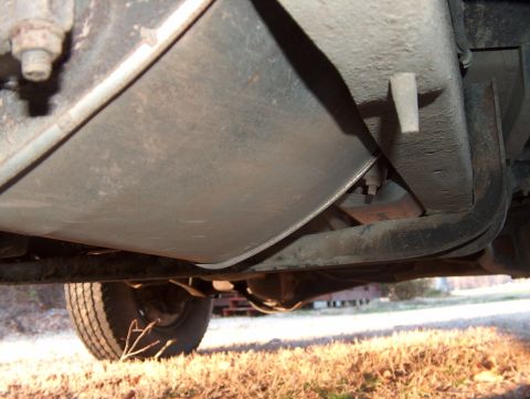 1991 Ford Bronco - The underside of a vehicle is captured from a low angle, revealing mechanical components and a tire.