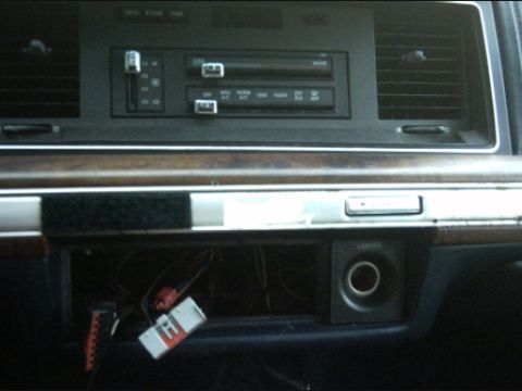 1991 Ford Crown Victoria LTD - The interior of a car shows the dashboard with climate controls and an open compartment.