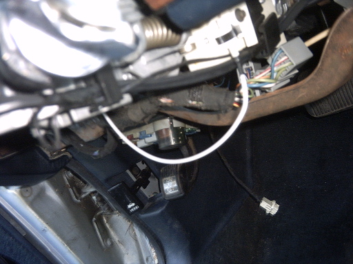 Interior view of wiring and pedals with a hood release lever